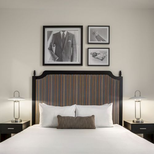 A neatly arranged bedroom with a bed, two bedside tables, lamps, and framed artwork above the headboard.