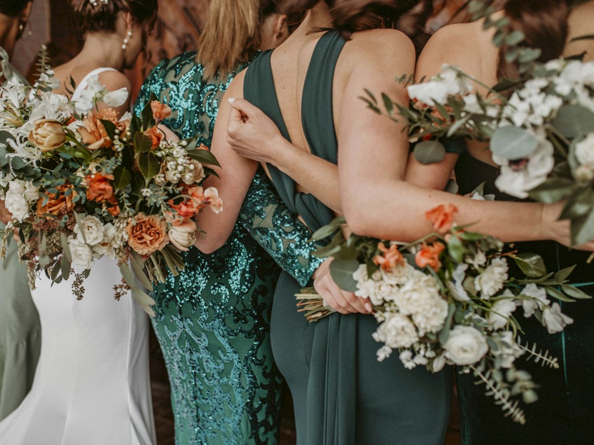 A group of people in dresses holding bouquets of flowers.